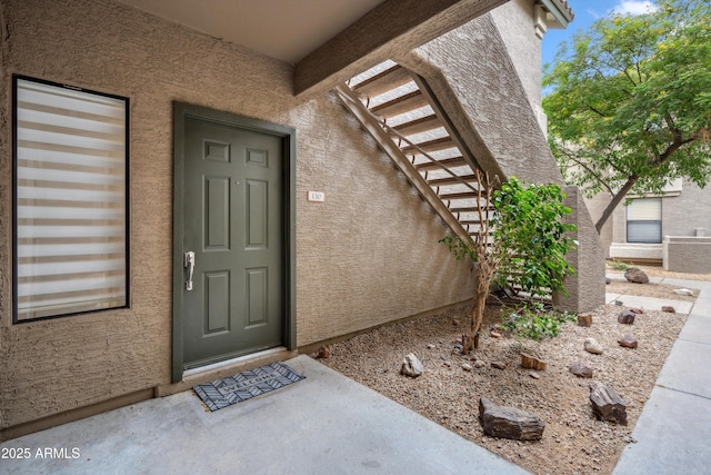 doorway to property featuring stucco siding