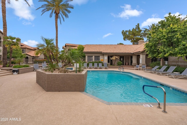 community pool with a patio and fence
