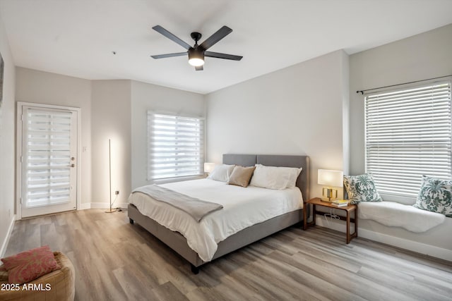 bedroom with light wood-type flooring, baseboards, and a ceiling fan
