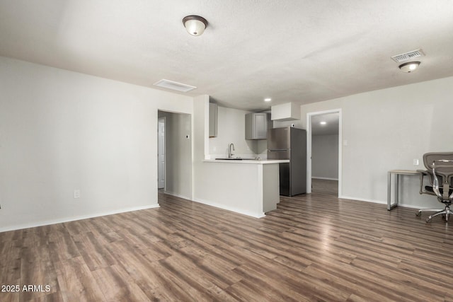 1424 S Bonarden Ln, Tempe, AZ 85281 - unfurnished living room with a sink, dark wood-style floors, baseboards, and visible vents