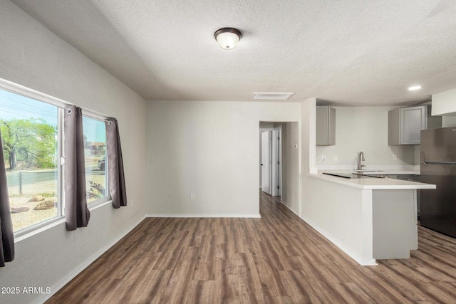 1424 S Bonarden Ln, Tempe, AZ 85281 - kitchen featuring a sink, light countertops, freestanding refrigerator, gray cabinetry, and wood finished floors