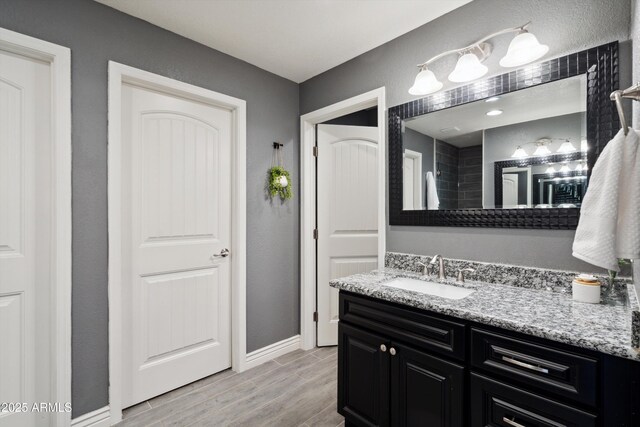 2726 E Fairmount Ave, Phoenix, AZ 85016 - full bathroom with baseboards, wood finished floors, and vanity