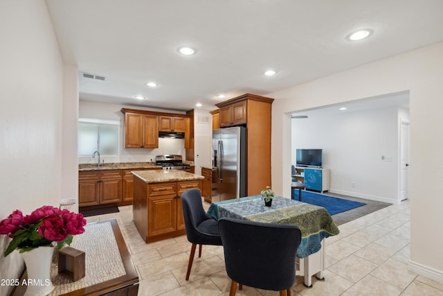 2726 E Fairmount Ave, Phoenix, AZ 85016 - kitchen featuring brown cabinets, appliances with stainless steel finishes, a sink, a kitchen island, and visible vents