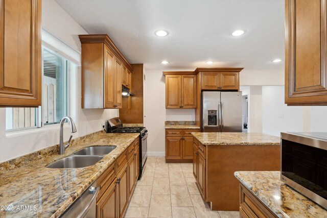 2726 E Fairmount Ave, Phoenix, AZ 85016 - kitchen with brown cabinets, a sink, light stone counters, under cabinet range hood, and stainless steel appliances