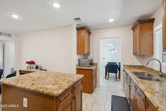 2726 E Fairmount Ave, Phoenix, AZ 85016 - kitchen with a sink, light stone counters, brown cabinets, and visible vents