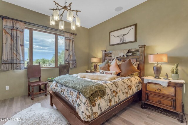 bedroom featuring light hardwood / wood-style flooring and a notable chandelier