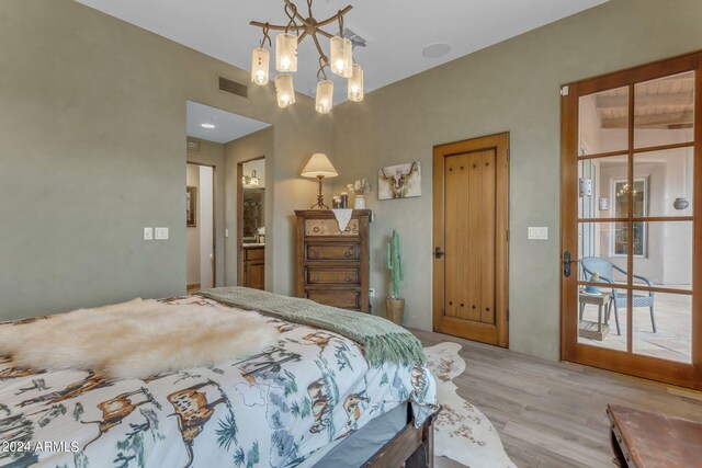 bedroom with light hardwood / wood-style flooring and a notable chandelier