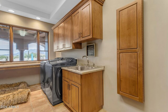 interior space with light tile patterned floors, sink, cabinets, and washing machine and dryer