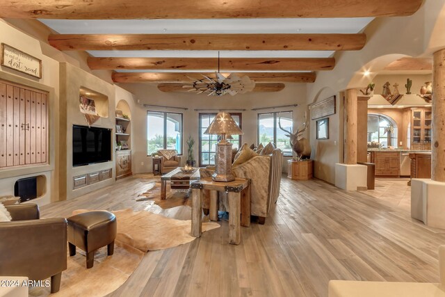 living room featuring beamed ceiling and light hardwood / wood-style flooring