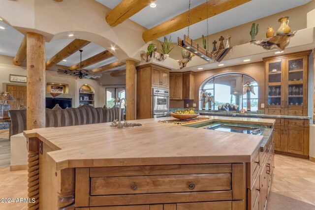 kitchen featuring a wealth of natural light, a kitchen island, sink, and butcher block counters