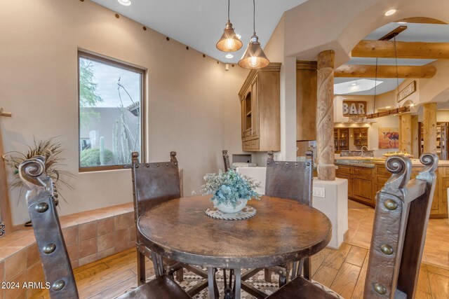 dining area with vaulted ceiling and light wood-type flooring