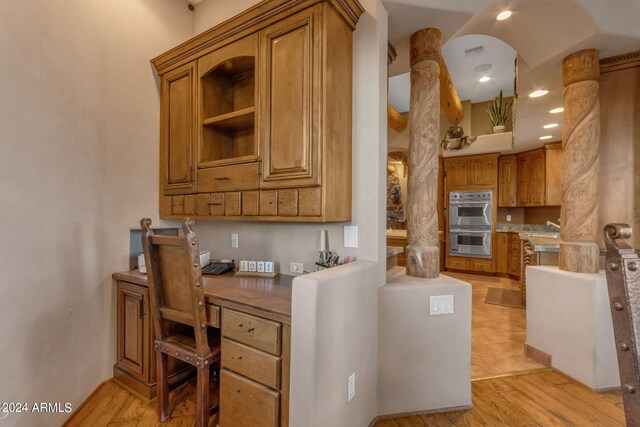 kitchen featuring double oven and light hardwood / wood-style flooring