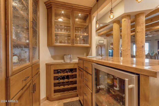 bar featuring light tile patterned flooring, pendant lighting, wine cooler, and sink