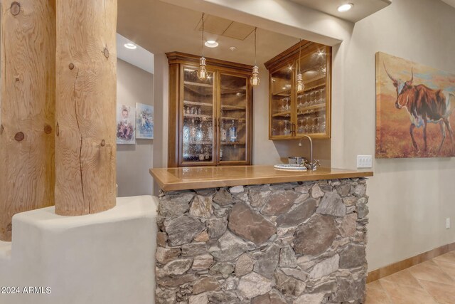 bar featuring decorative light fixtures and sink