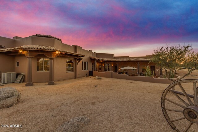 back house at dusk featuring central AC unit