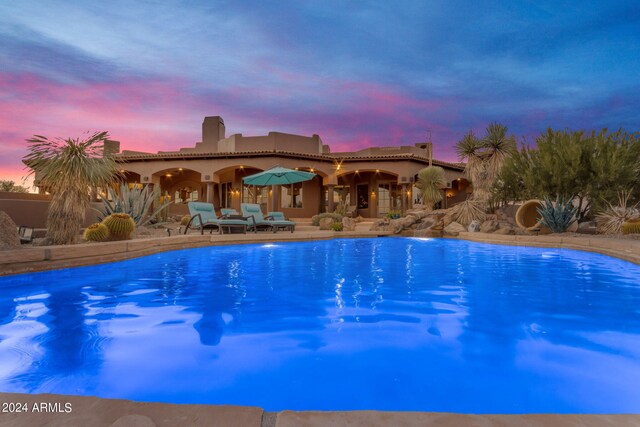 pool at dusk with a patio