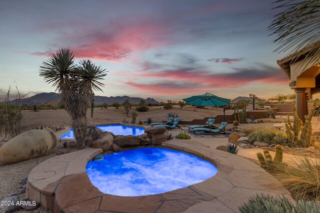 pool at dusk with a patio