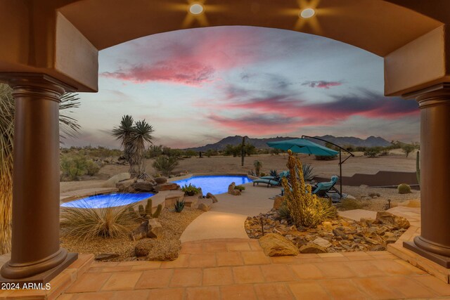 patio terrace at dusk featuring a mountain view