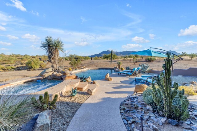 view of pool with a mountain view and a patio