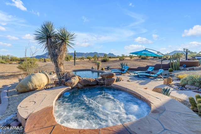 view of pool with a mountain view and an in ground hot tub