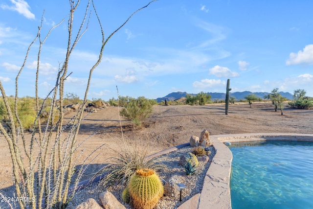 view of swimming pool with a mountain view and a rural view