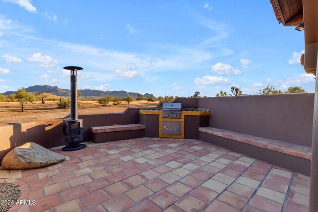 view of patio / terrace with area for grilling, a grill, and a mountain view