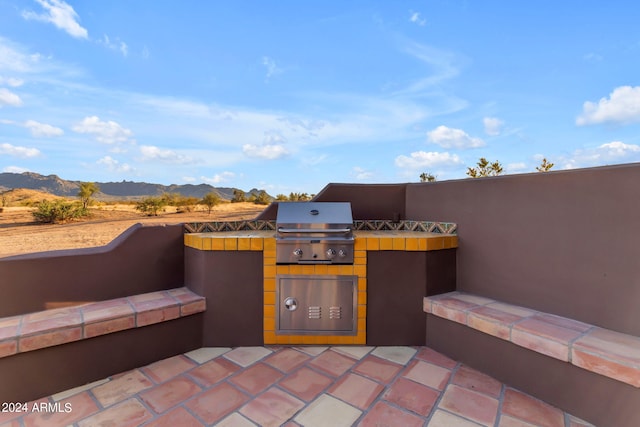 view of patio / terrace with a mountain view, an outdoor kitchen, and area for grilling