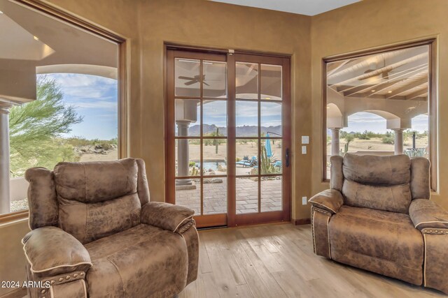 living area with ceiling fan and light hardwood / wood-style floors