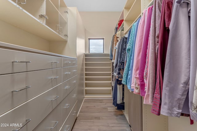 walk in closet with light hardwood / wood-style flooring