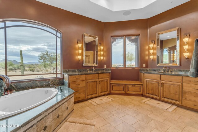 bathroom with tiled bath and vanity