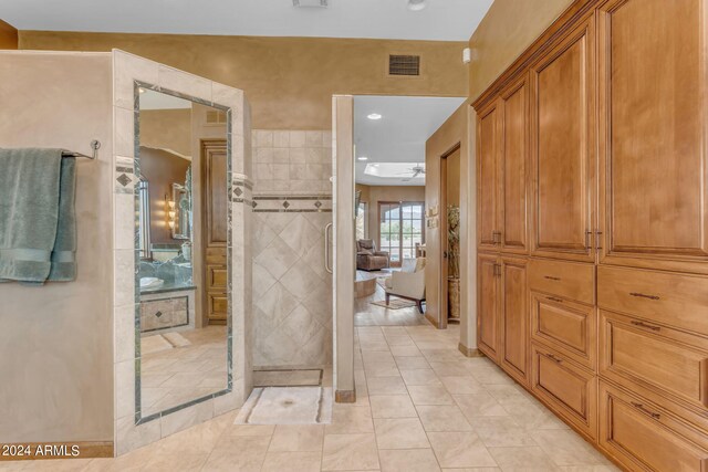 bathroom featuring tiled shower, vanity, ceiling fan, and tile patterned floors