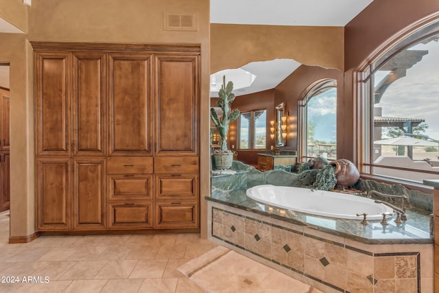 bathroom with tile patterned flooring and a relaxing tiled tub