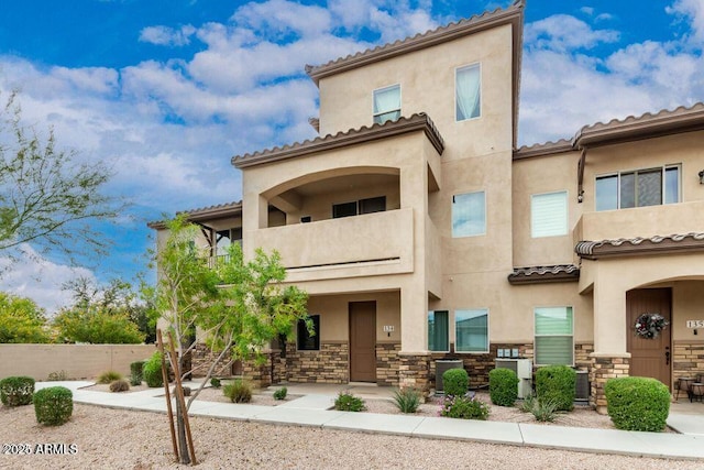 view of front of house featuring stone siding and stucco siding