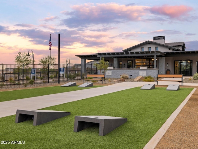 view of home's community with a lawn and fence