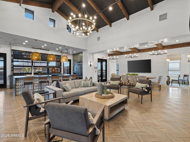 living room featuring a chandelier, visible vents, high vaulted ceiling, and beam ceiling