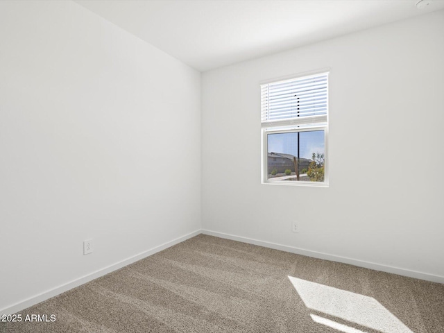 carpeted spare room with baseboards