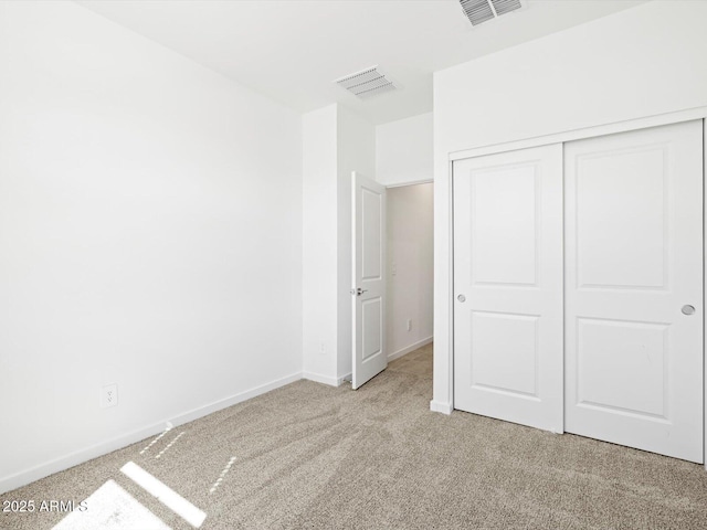 unfurnished bedroom featuring visible vents, baseboards, a closet, and carpet flooring