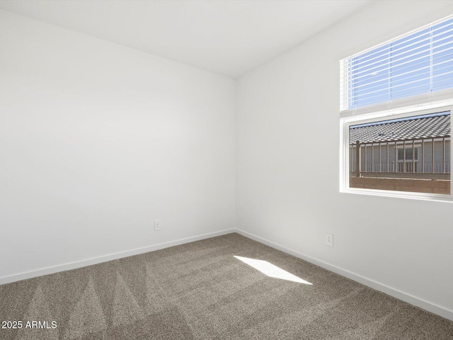 carpeted spare room with baseboards