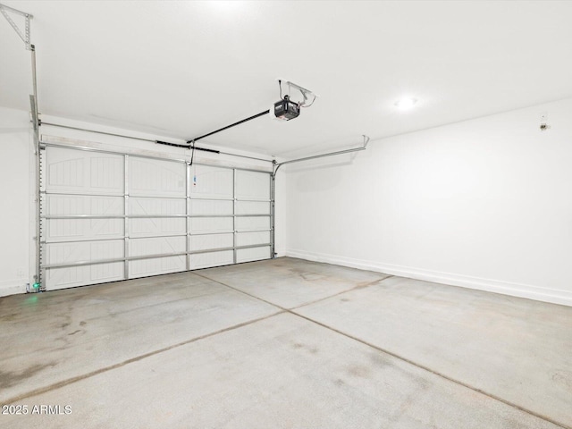 garage with baseboards and a garage door opener