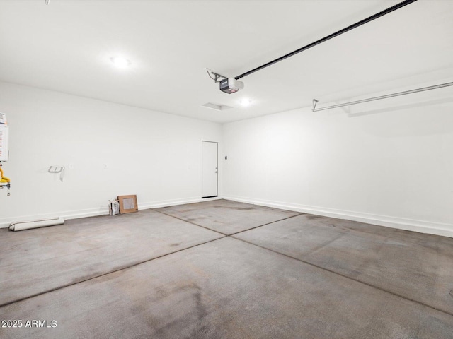 garage featuring a garage door opener and baseboards