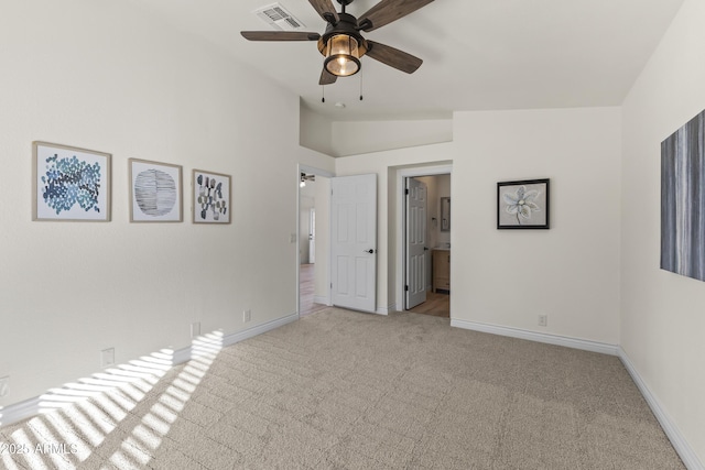 unfurnished bedroom featuring ceiling fan, lofted ceiling, ensuite bathroom, and light carpet