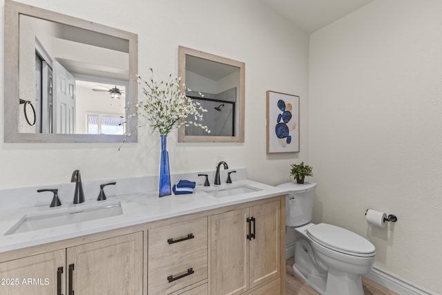 bathroom featuring an enclosed shower, vanity, ceiling fan, and toilet