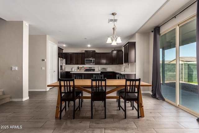 dining room featuring baseboards, wood tiled floor, and a notable chandelier