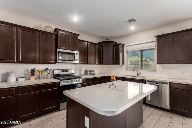 kitchen featuring visible vents, appliances with stainless steel finishes, decorative backsplash, and a sink