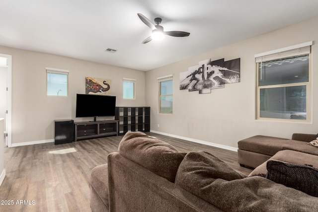 living area featuring ceiling fan, visible vents, baseboards, and wood finished floors