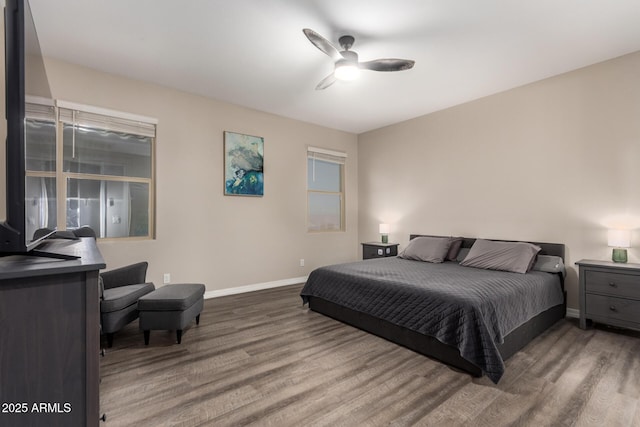 bedroom with ceiling fan, baseboards, and wood finished floors