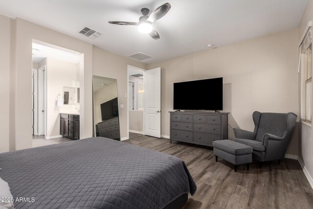 bedroom featuring ceiling fan, ensuite bathroom, wood finished floors, visible vents, and baseboards