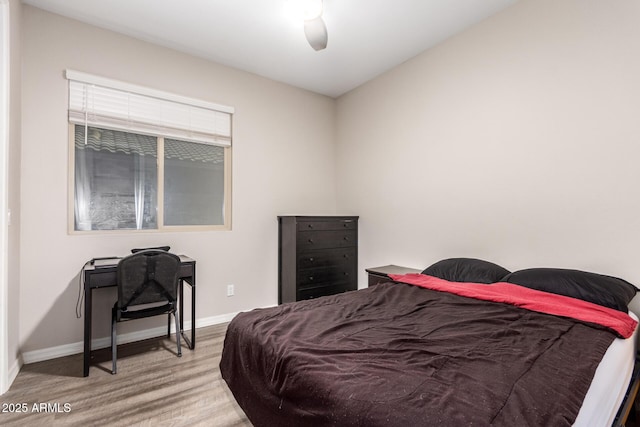 bedroom with wood finished floors, a ceiling fan, and baseboards