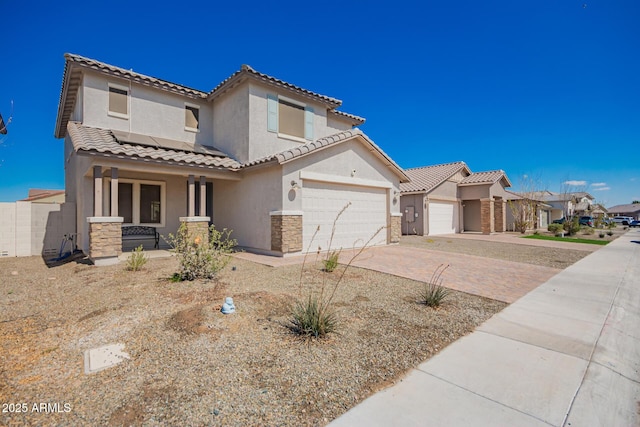 mediterranean / spanish-style home with a tiled roof, decorative driveway, roof mounted solar panels, a porch, and stucco siding