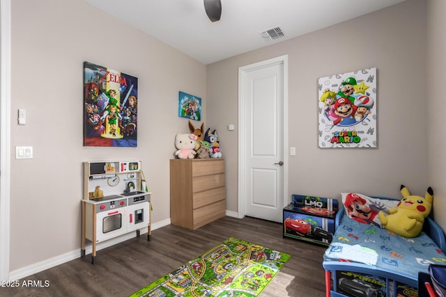 bedroom featuring a ceiling fan, visible vents, baseboards, and wood finished floors